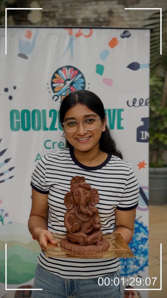 A participant proudly holding the clay Ganesha she made at a Cool2Creative workshop